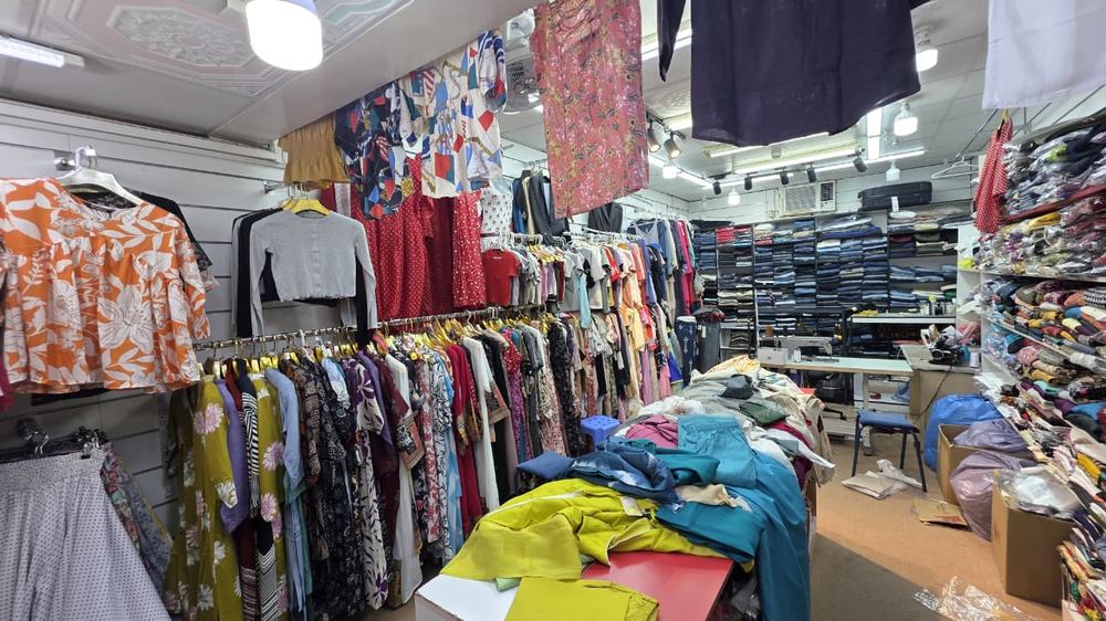 Shop aisle with jeans wall and clothing racks at Safa Marwa, Bur Dubai