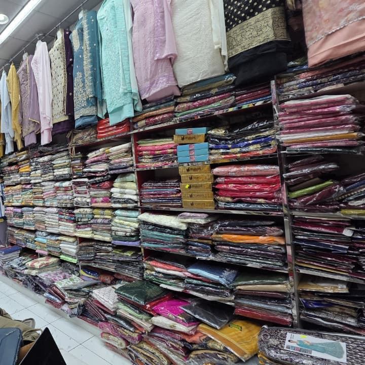 Shelves stacked with folded salwar suit sets and dress material at Safa Marwa